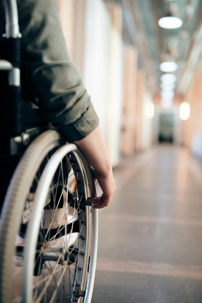 Wheelchair user moving through a wide hallway